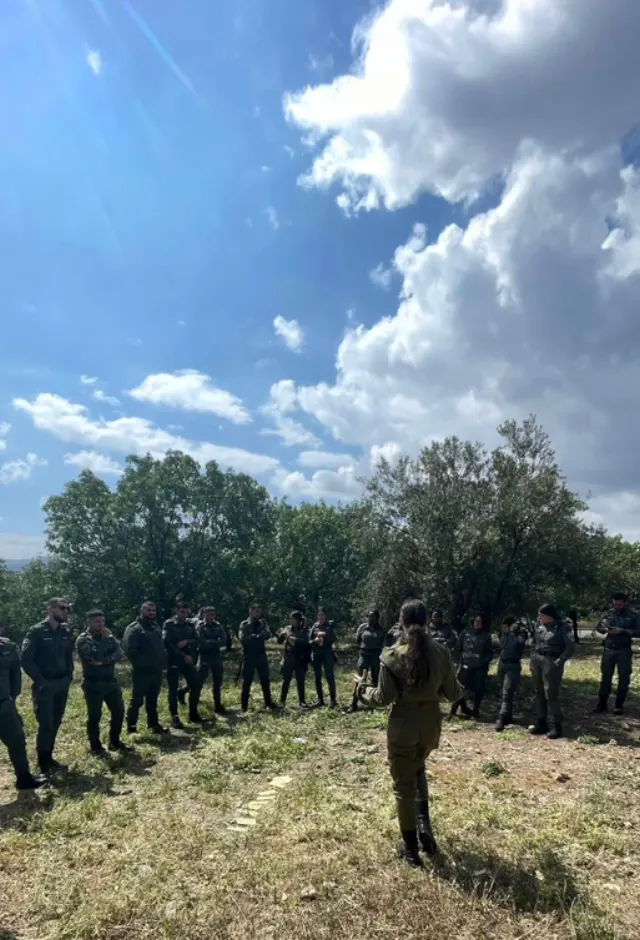 קרין באקון מדברת מול קבוצת חיילים בשטח